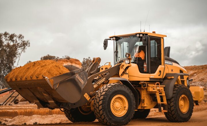 yellow and black heavy equipment on brown field during daytime